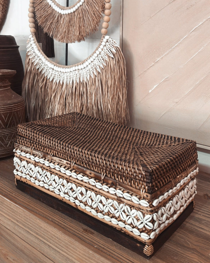 Woven handbag with fringe details on a wooden floor