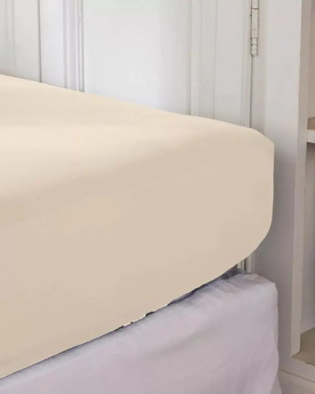 Beige fitted sheet on a bed in a bedroom setting