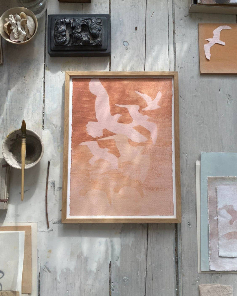 Framed artwork on a rustic wooden wall with various items.