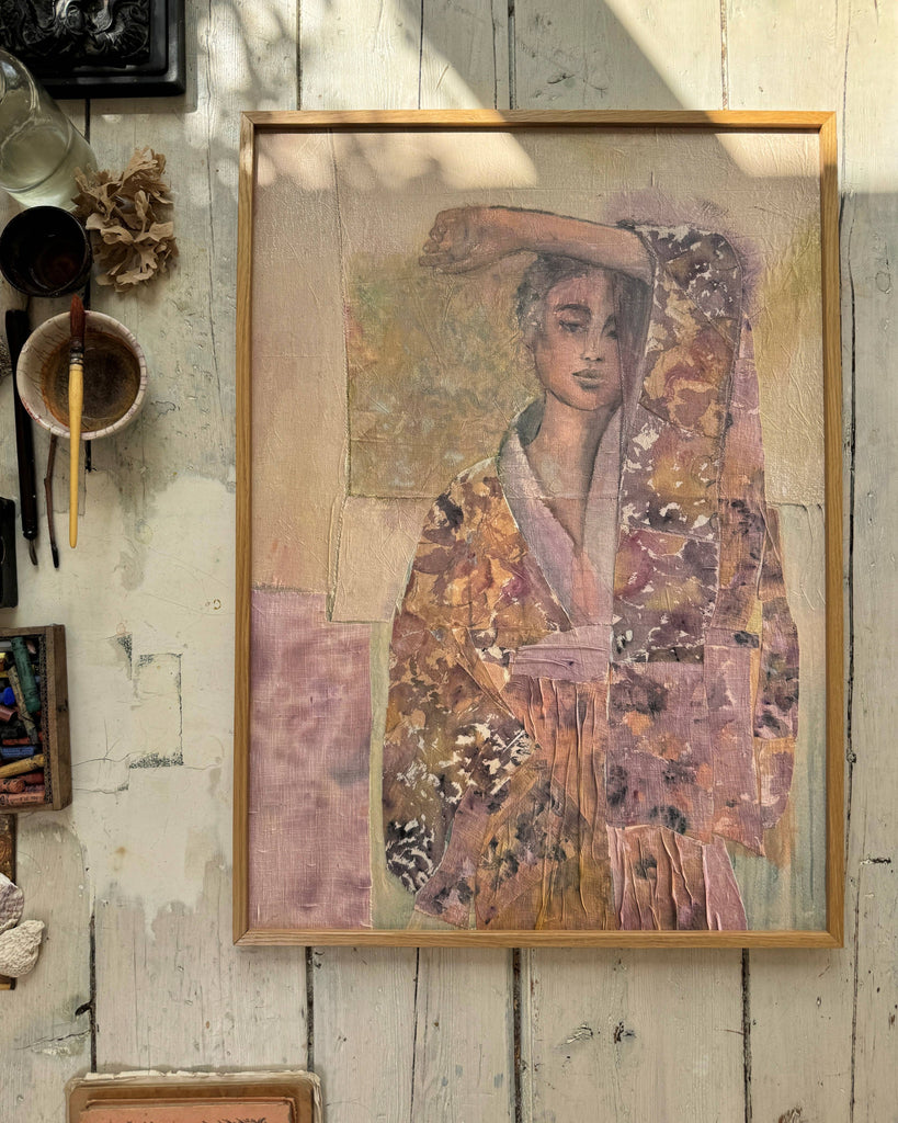 Framed artwork of a person in traditional attire on a rustic wooden wall.