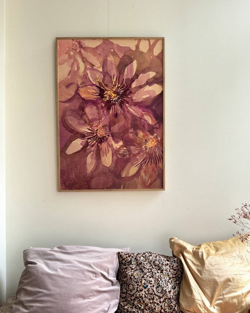 Floral painting on a wall above a sofa with decorative pillows.
