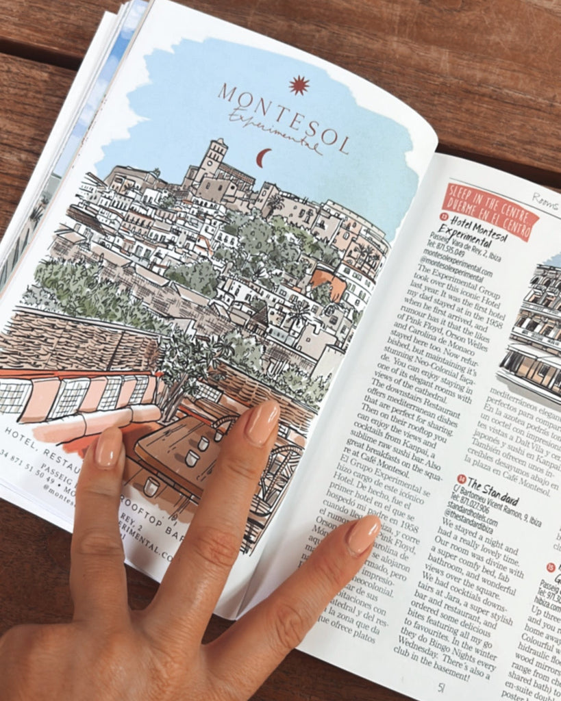 Open book with a colorful illustration of a cityscape on a wooden surface