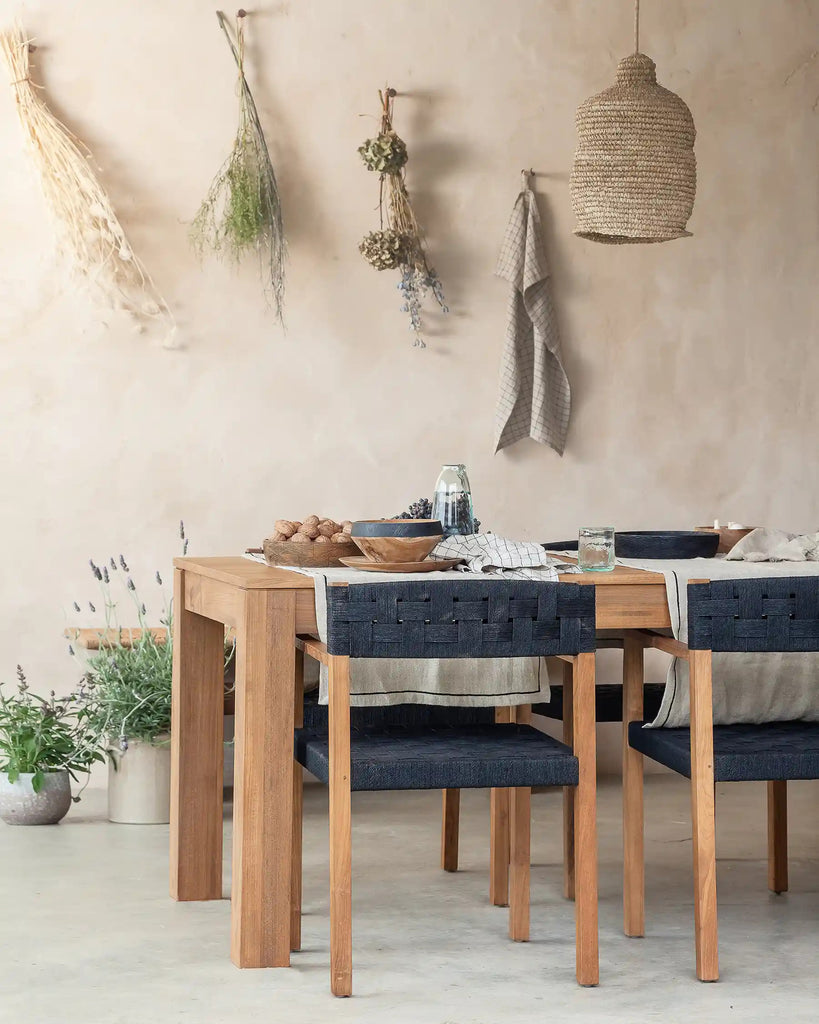 Dining area with wooden table and chairs against a beige wall.