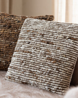 Textured pillows on a sofa with a neutral background