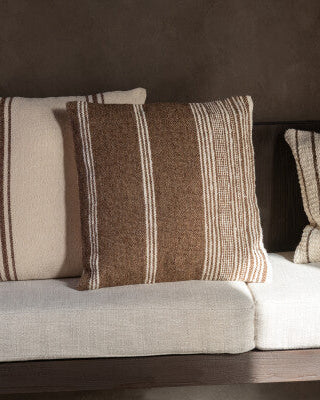 Three patterned pillows on a sofa against a dark background