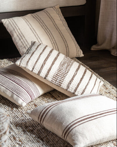 Striped cushions on a sofa and floor in a living room setting