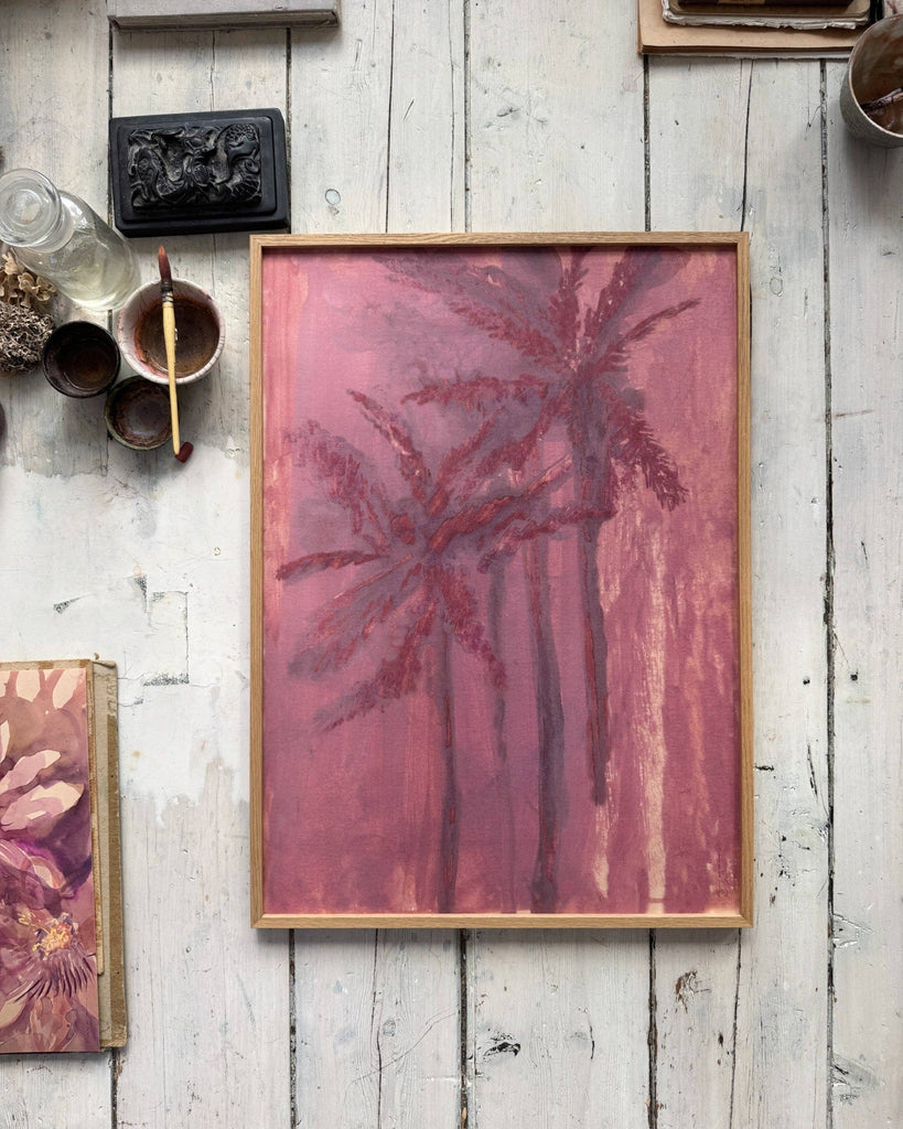 Framed abstract art with palm tree design on a rustic wooden wall.