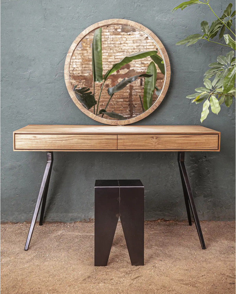 Wooden console table with a round mirror above it against a gray wall.